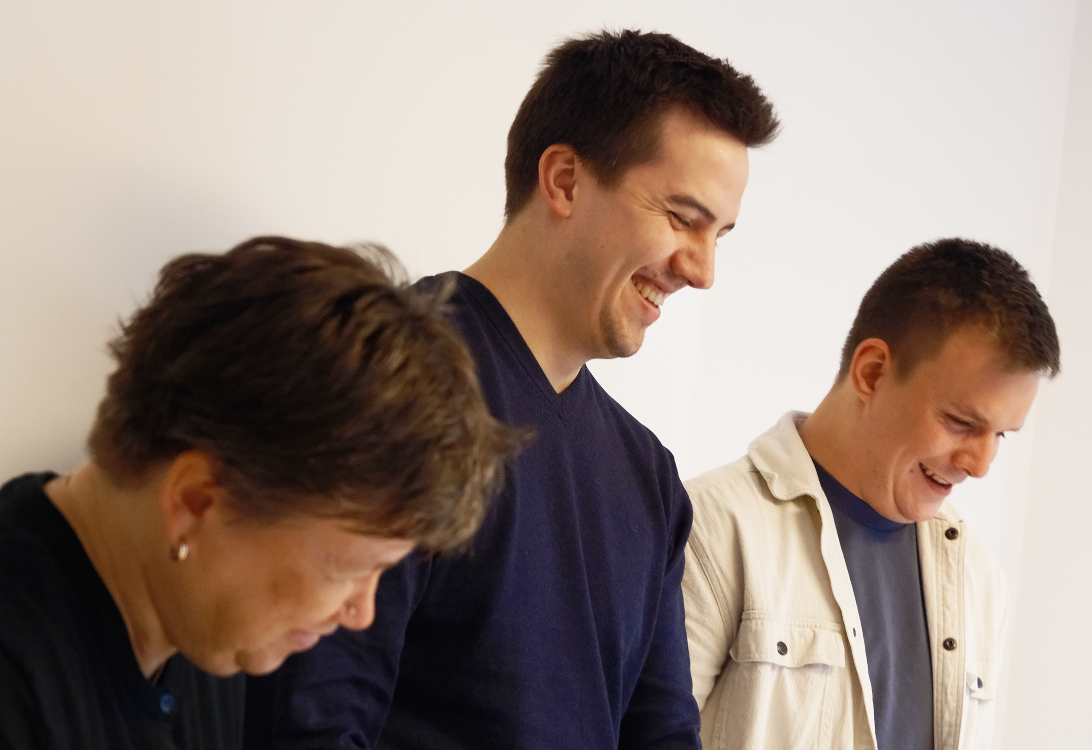 Drei Menschen stehen zusammen und lachen - TBE ingenieurbüro für Tragwerksplanung